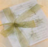 White flower overlay with green ribbon wedding invitation